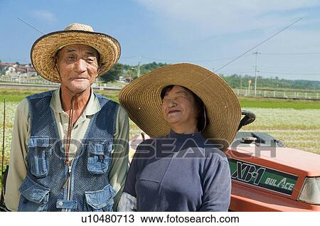 Stock Image - Farmer Couple in Rice Field. Fotosearch