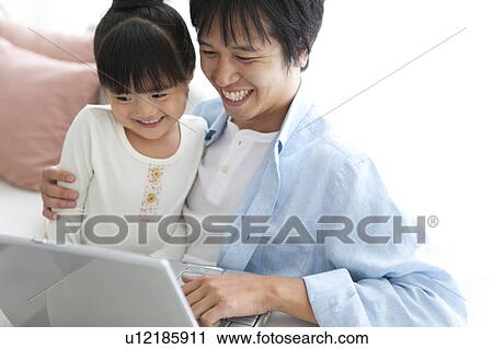 Stock Image - Father and Daughter Using Laptop. Fotosearch