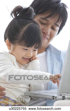 Stock Photography - Father and Daughter Using Laptop. Fotosearch