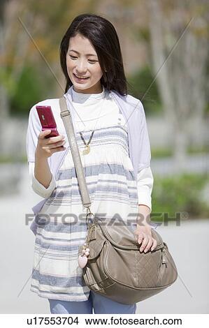 Picture - Female University Student Text Messaging. Fotosearch