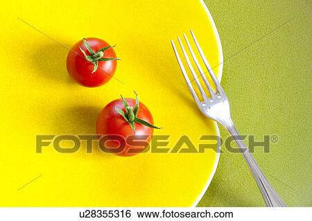 Stock Photograph - Fork and Two Tomatoes on Yellow Plate. Fotosearch