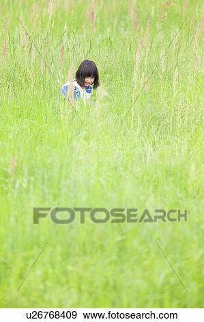 Stock Photo - Girl in Field of Tall Grass. Fotosearch