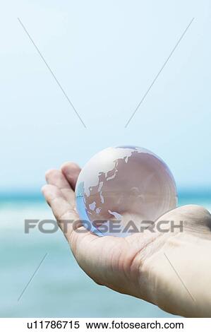 Stock Photography - Glass Globe in Person's Hand. Fotosearch