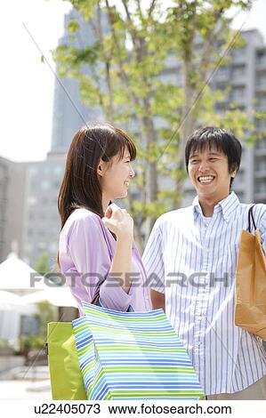 Stock Image - Happy Young Couple with Shopping Bags. Fotosearch