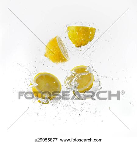 Stock Photo - Lemon Halves Falling Into Water. Fotosearch