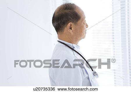 Stock Photograph - Male Doctor Looking Through Window. Fotosearch