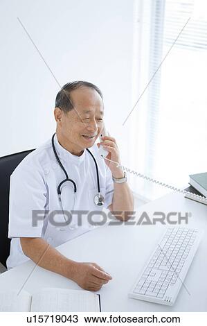 Stock Image - Male Doctor on Phone. Fotosearch