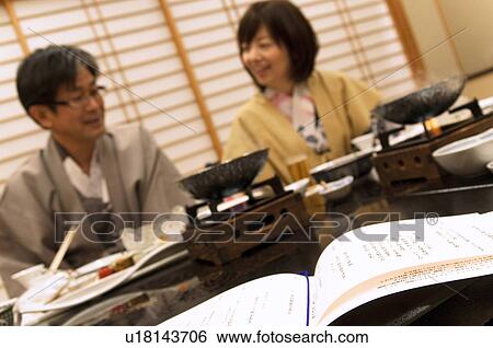 Stock Photograph - Mature Couple Having Dinner, Menu In Foreground. Fotosearch