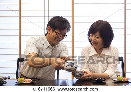 Stock Photograph - Mature Couple Having Tea and Sweets. Fotosearch