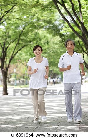 Picture - Mature Couple Jogging in Park. Fotosearch