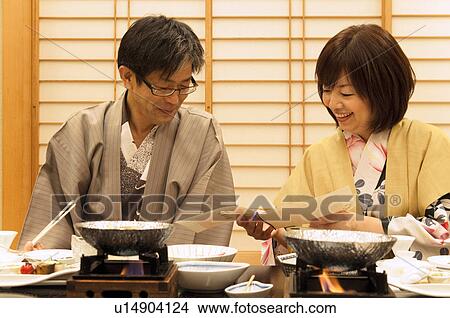 Picture - Mature Couple Looking at Menu at Dinner Table. Fotosearch