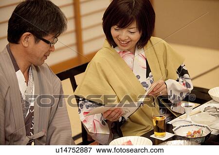 Stock Photo - Mature Couple Looking at Menu at Dinner Table. Fotosearch