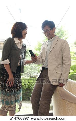 Mature Couple with Mobile Phone in Lobby View Large Photo Image Stock Photo - Mature Couple with Mobile Phone in Lobby. Fotosearch