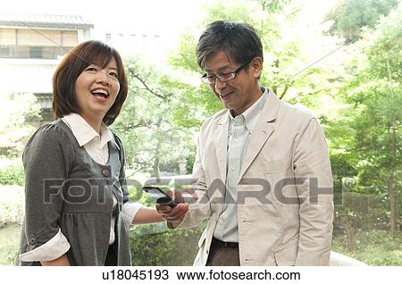 Stock Image - Mature Couple with Mobile Phone. Fotosearch