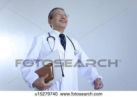 Stock Image - Mature Doctor Walking, Low Angle View. Fotosearch