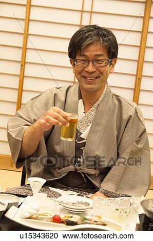 Stock Image - Mature Man Having Beer and Dinner. Fotosearch