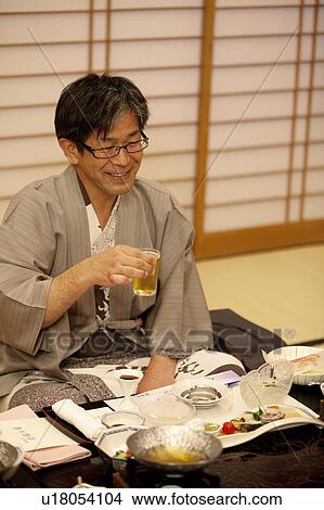 Picture - Mature Man Having Beer with Dinner. Fotosearch
