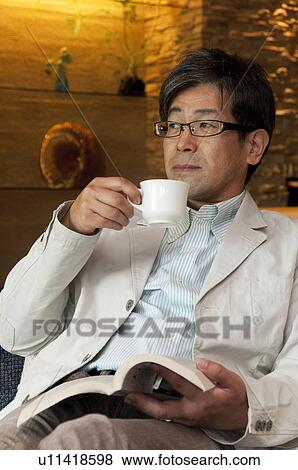 Mature Man Having Coffee Whilst Reading Book View Large Photo Image Stock Photo - Mature Man Having Coffee Whilst Reading Book. Fotosearch