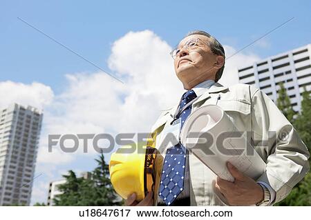 Mature Man Holding Blueprint and Hardhat View Large Photo Image Stock Photo - Mature Man Holding Blueprint and Hardhat. Fotosearch