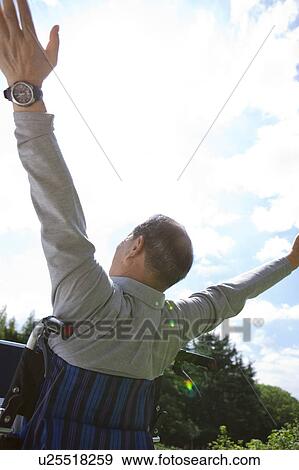 Stock Photo - Mature Man in Wheelchair Spreading Arms. Fotosearch