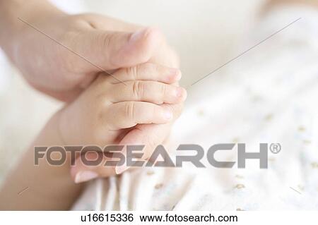 Stock Photograph - Mother and baby holding hands. Fotosearch