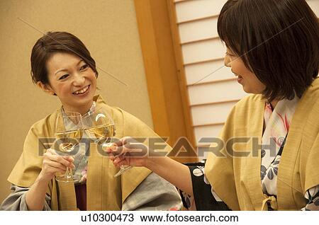 Stock Image - Mother and Daughter Toasting with White Wine. Fotosearch