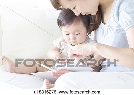 Mother and reading book to baby View Large Photo Image Stock Photograph - Mother and reading book to baby. Fotosearch