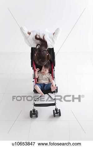 Mother Consoling Baby Boy in Buggy View Large Photo Image Stock Photo - Mother Consoling Baby Boy in Buggy. Fotosearch