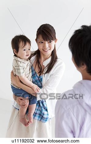 Stock Image - Mother, Father and Baby Boy Looking at Each Other. Fotosearch