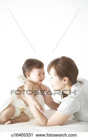 Stock Image - Mother holding a crying baby. Fotosearch