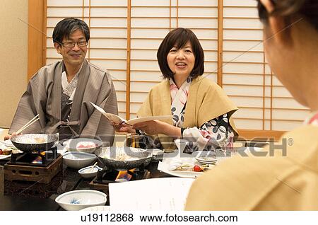 Parents Looking at Menu and Talking To Their Adult Daughter View Large Photo Image Stock Photo - Parents Looking at Menu and Talking To Their Adult Daughter. Fotosearch