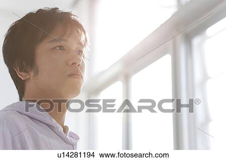 Pensive Young Man Against Sunlight, Low Angle View View Large Photo Image Picture - Pensive Young Man Against Sunlight, Low Angle View. Fotosearch