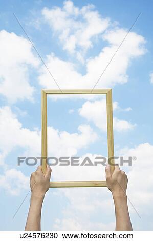 Stock Image - Person Holding Up Picture Frame. Fotosearch