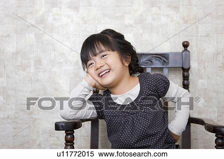 Stock Photography - Portrait of Young Girl Sitting on Chair. Fotosearch