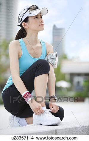 Picture - Sporty Young Woman Tying Shoe Laces. Fotosearch