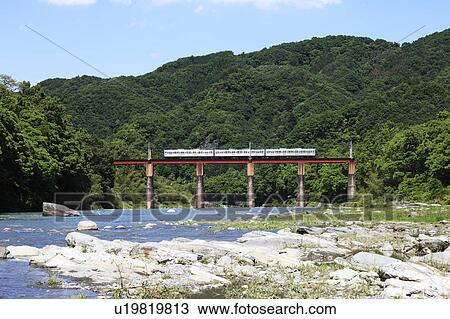 Stock Image - Train crossing railway bridge, Saitama Prefecture, Honshu, Japan. Fotosearch
