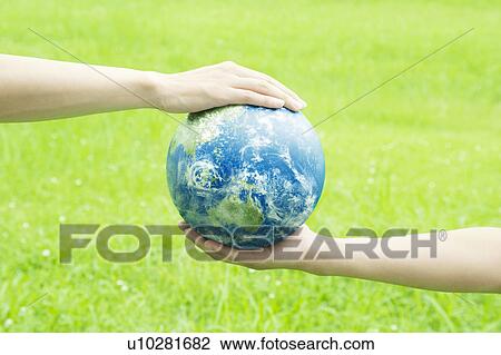 Stock Image - Two People Holding Earth. Fotosearch