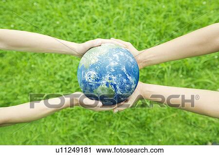 Stock Image - Two People Holding Globe. Fotosearch