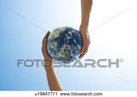 Stock Image - Two People Holding Globe. Fotosearch