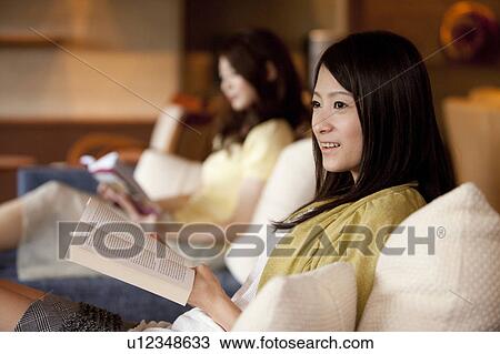 Stock Image - Two Women Reading Book. Fotosearch