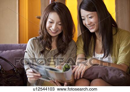 Stock Image - Two Women Reading Magazine. Fotosearch