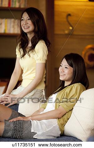 Two Young Women Sitting On Sofa View Large Photo Image Stock Image - Two Young Women Sitting On Sofa. Fotosearch