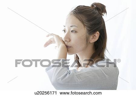 Stock Image - Woman wiping her mouth with her hand, Tokyo Prefecture, Japan. Fotosearch