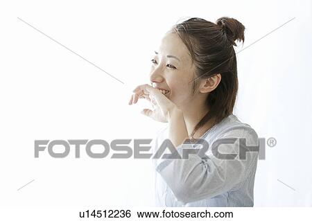 Stock Photograph - Woman wiping her mouth with her hand, Tokyo Prefecture, Japan. Fotosearch