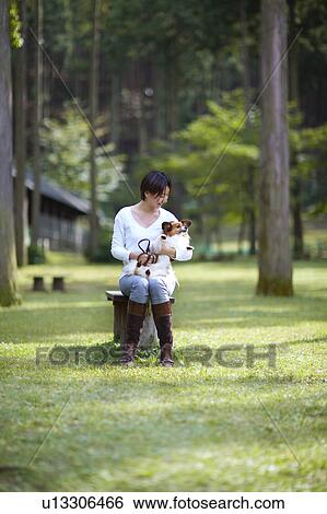 Stock Photograph - Woman with Papillon in Park. Fotosearch