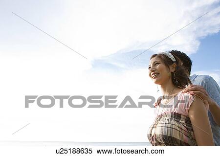 Stock Photography - Young Couple Against Sky. Fotosearch
