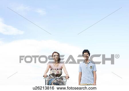 Stock Photograph - Young Couple, Girlfriend Cycling. Fotosearch