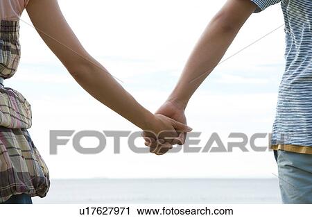 Stock Image - Young Couple Holding Hands. Fotosearch