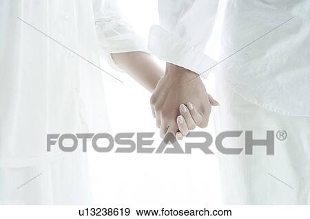 Stock Photo - Young Couple Holding Hands. Fotosearch