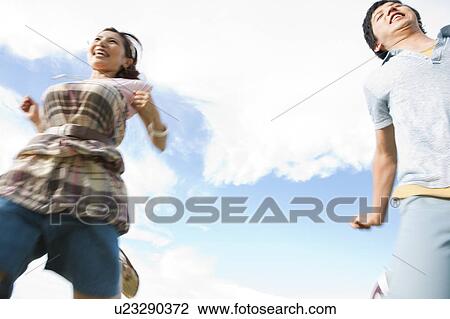 Young Couple Running, Low Angle View View Large Photo Image Stock Image - Young Couple Running, Low Angle View. Fotosearch